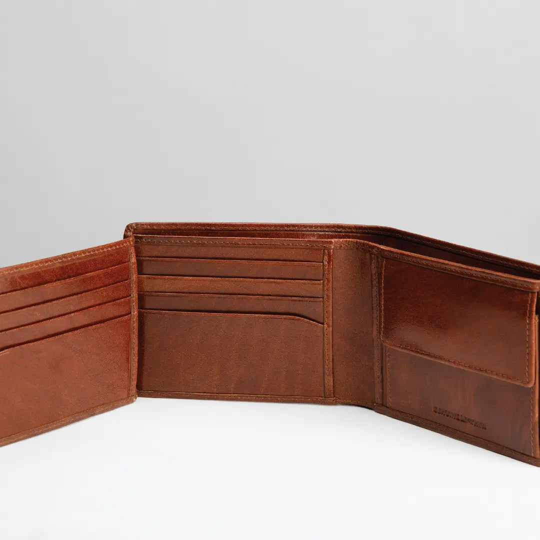 An open brown leather bifold wallet showing its interior card slots, cash pocket, and ID window against a light gray background.