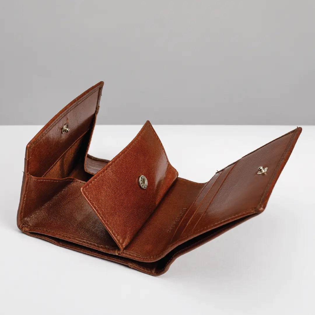An open brown leather wallet with multiple card slots and a central snap-tab closure, photographed on a clean white surface against a light gray background.