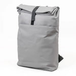 Grey roll-top backpack with velcro strap to close on a white background.