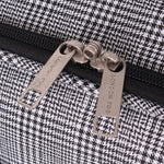 Close-up of a houndstooth-patterned bag with 'London Fog' branding on zipper pulls.